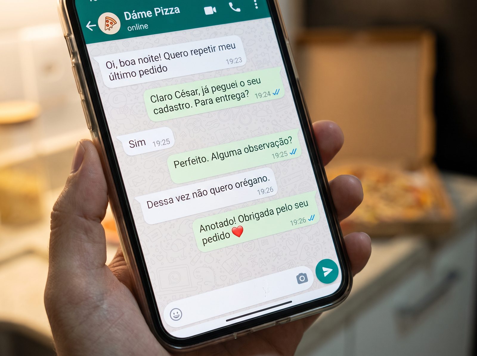 Celular na mão mostrando uma conversa de atendimento no WhatsApp em que o pedido é retomado, ajustado e confirmado
